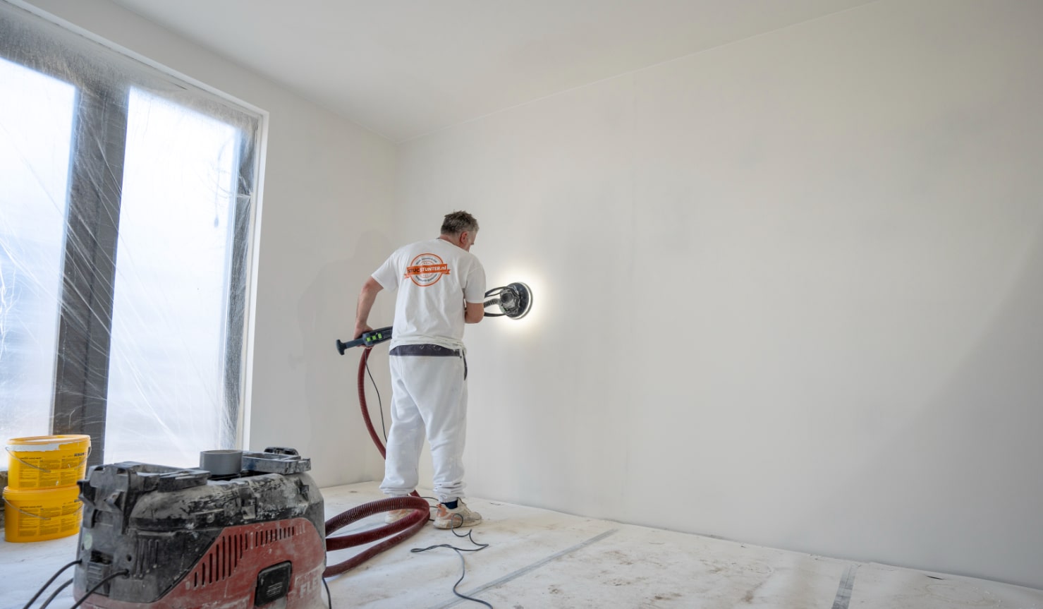 dunpleister wanden schuren voor een gladde afwerking in nieuwbouwwoning